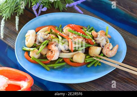 Plat asiatique aux fruits de mer, légumes à la sauce soja sur une assiette. Pour un menu asiatique Banque D'Images