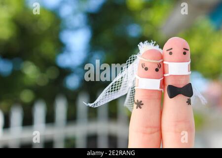 Fingers art de couple heureux dans le masque médical de COVID-2019. Concept de cérémonie de mariage. Banque D'Images