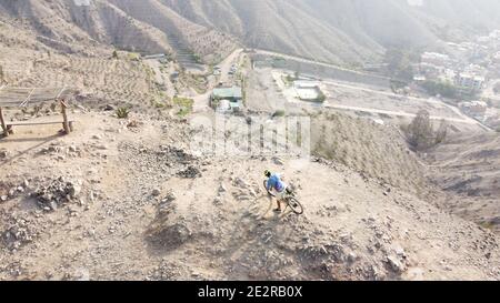 Homme à vélo de montagne le long du terrain rocheux stérile Banque D'Images