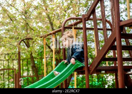 Petite fille mignonne sur une balançoire de mer à l'aire de jeux.petite fille mignonne sur balançoire de mer. Sur l'aire de jeux dans le parc à l'extérieur. Marcher dans la maternelle Banque D'Images