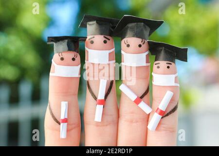 L'art des doigts des étudiants dans le masque médical de COVID-2019. Diplômés titulaires de leur diplôme après l'obtention de leur diplôme. Banque D'Images