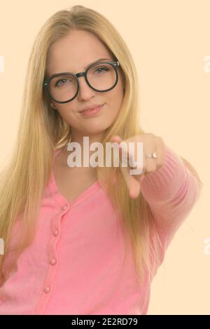 Studio shot of young beautiful teenage girl pointing at camera Banque D'Images