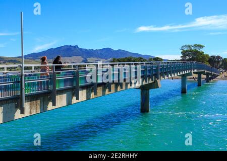 Raglan, Nouvelle-Zélande, en été. La passerelle te Kopua traverse le port jusqu'à une plage de sable Banque D'Images