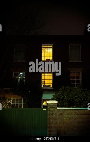 Accueil avec fenêtres éclairées la nuit - Clapham/Batteresea - Londres, Royaume-Uni Banque D'Images