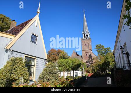 Broek à Waterland, petite ville avec maisons traditionnelles en bois anciennes et peintes, Hollande du Nord, pays-Bas, avec le clocher de l'église Banque D'Images