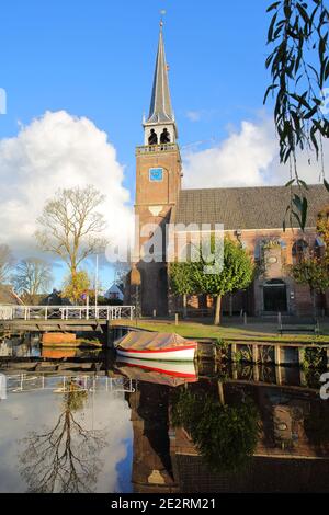 Broek à Waterland, une petite ville avec des maisons traditionnelles anciennes et peintes en bois, Hollande du Nord, pays-Bas, avec des reflets de l'église Banque D'Images