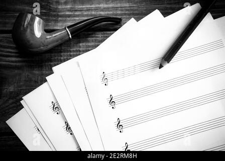 Papier de partition de musique vierge et pipe de fumée en noir et blanc. Banque D'Images