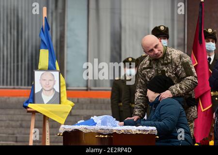 Non exclusif: ZAPORIZHHIA, UKRAINE - 14 JANVIER 2021 - la mère et un frère aîné du soldat péri Oleh Andriienko grieve pendant la période de la fête Banque D'Images