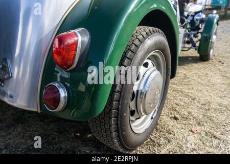 Gros plan de la roue arrière et de l'arche de Un haut ouvert léger Lotus Seven, vert de course britannique des années 1960 voiture de sport Banque D'Images