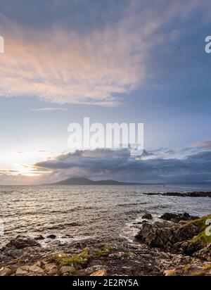 Vue sur une mer agitée au coucher du soleil vers l'île de Clare de Roonagh Pier, à l'ouest de Louisbourg, Comté de Mayo, Irlande Banque D'Images