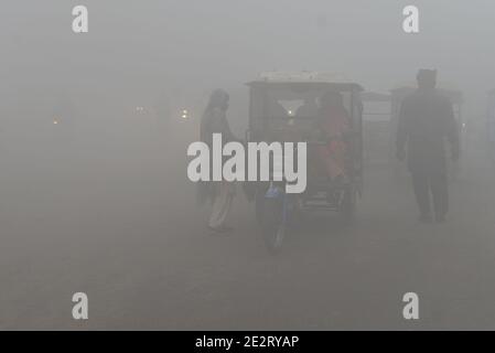 Lahore, Pakistan. 15 janvier 2021. Les navetteurs et les habitants pakistanais se rendent dans un climat de brouillard dense le matin froid de l'hiver à Lahore. L'intensité du brouillard, la visibilité a été réduite à zéro, ce qui rend difficile la manœuvre des véhicules sur les routes. La police de la circulation a émis des directives de sécurité à l'intention des personnes après que le brouillard a roulé dans la ville. Crédit : Pacific Press Media production Corp./Alay Live News Banque D'Images