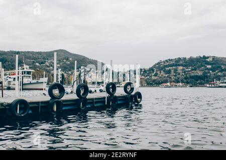 Côme, région Lombardie, Italie - 14 janvier 2021 : bateaux dans le port du lac de Côme, quai du ferry en sombre journée d'hiver. Location de bateaux pour les touristes et le public Banque D'Images