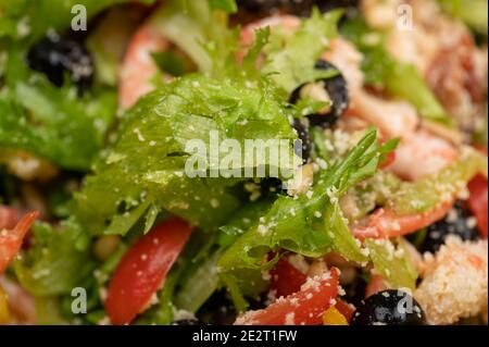 Salade de légumes avec crevettes et pignons sur une assiette. Plats faits maison. Gros plan Banque D'Images