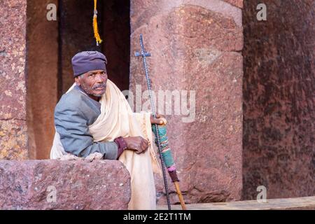 Pèlerin avec une croix priant tôt le matin à l'église Rock-hewn Felsenkirche site du patrimoine mondial de l'UNESCO, Lalibela, Ethiopie, Afrique Banque D'Images