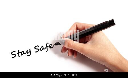 Main tenant le stylo écrire rester en sécurité sur le papier blanc Banque D'Images