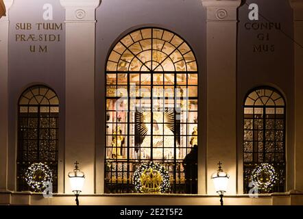 La porte de l'Aube ou Aurora à Vilnius, la chapelle notre-Dame de la porte de l'Aube est au milieu derrière la fenêtre vitrée, vue nocturne avec de la neige Banque D'Images