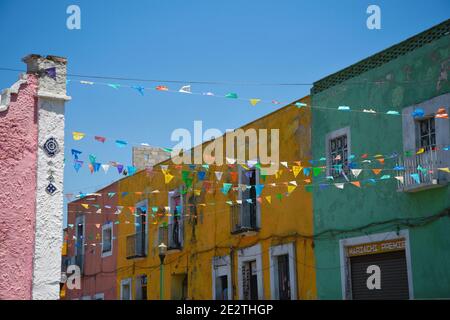 Maison de style colonial et façades de magasins avec festivités locales drapeaux colorés à Puebla de Zaragoza, Mexique. Banque D'Images