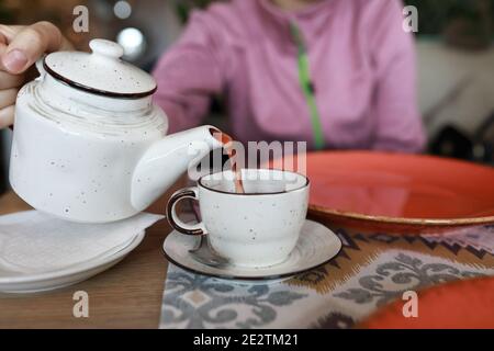Femme qui verse du thé aux fruits dans un restaurant Banque D'Images