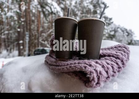 Deux tasses en papier avec café gardent au chaud sur un foulard dans la neige, conte d'amour d'hiver Banque D'Images