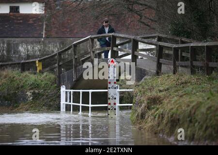 Un homme traverse un pont au-dessus d'une route inondée dans le village de Great Easton, Dunmow, où la rivière Chelmer éclate ses rives. Des avertissements d'inondation ont été émis vendredi dans de grandes parties de l'Angleterre à la suite de fortes pluies. Banque D'Images