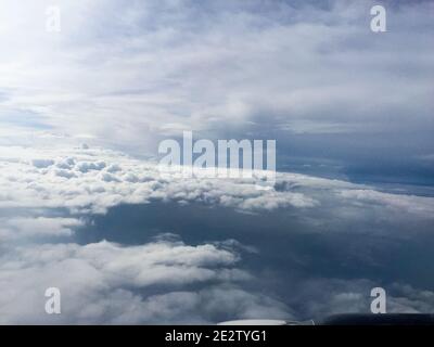 Les nuages denses gris et blancs obscurcissent la vue en dessous tandis qu'au-dessus des nuages cumulous lumineux dérive par la fenêtre. La troposphère est une partie importante de notre . Banque D'Images