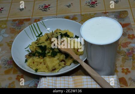 Une tasse de levain et une assiette de pommes de terre bouillies et la ciboulette comme un plat traditionnel de village dans le passé Banque D'Images