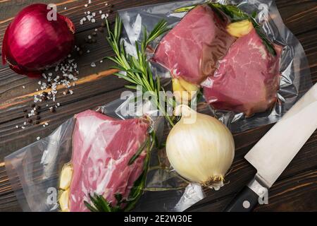Produits en conditionnement sous vide, sur une planche en bois. Légumes, viande de poisson, dolma, kurza. Pandémie de quarantaine Banque D'Images