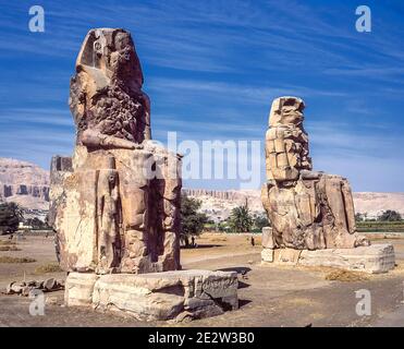 Louxor. C'est le site archéologique 1350BC au Colossi de Memnon de l'Égypte ancienne, non loin du Nil et de la ville de Louxor connu auparavant sous le nom de Thèbes. Les statues sont du Pharaon Amenhotep III, il y a deux petites statues à ses pieds, l'une étant sa mère, l'autre son épouse. Initialement construit pour protéger l'entrée du temple d'Amenotep contre le mal, ils ont également été vus pour protéger la rive ouest du Nil. Les Colossi ont subi des dommages importants après le tremblement de terre, mais après 3500 ans, ils restent debout. Banque D'Images