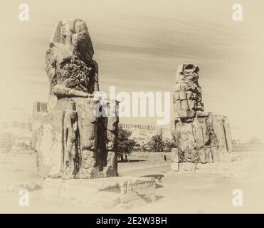 Louxor. C'est le site archéologique 1350BC au Colossi de Memnon de l'Égypte ancienne, non loin du Nil et de la ville de Louxor connu auparavant sous le nom de Thèbes. Les statues sont du Pharaon Amenhotep III, il y a deux petites statues à ses pieds, l'une étant sa mère, l'autre son épouse. Initialement construit pour protéger l'entrée du temple d'Amenotep contre le mal, ils ont également été vus pour protéger la rive ouest du Nil. Les Colossi ont subi des dommages importants après le tremblement de terre, mais après 3500 ans, ils restent debout. Banque D'Images