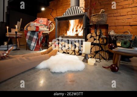 Femme couchée par la cheminée décorée pour le Nouveau Vacances d'années à l'intérieur de maison confortable Banque D'Images