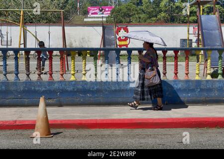 Guatemala, Amérique centrale: Femme maya en robe traditionnelle et parapluie Banque D'Images