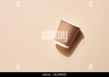 Une tasse jetable sur beige avec ombre des feuilles sur la plage. Aucun gaspillage. Environnement de pollution. Vue de dessus. Banque D'Images