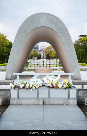 Le Cenotaph au Parc commémoratif de la paix d'Hiroshima, Hiroshima, Japon, en début de soirée. En regardant à travers le Cenotaph vers le Mémorial de la paix d'Hiroshima. Banque D'Images