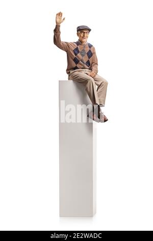 Homme âgé assis sur une colonne et agitant à la caméra isolé sur fond blanc Banque D'Images