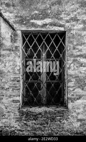 Une fenêtre barrée dans un bâtiment résidentiel dans le centre historique de la ville médiévale de Monticchiello près de Pienza dans la province de Sienne, Toscane, Italie Banque D'Images