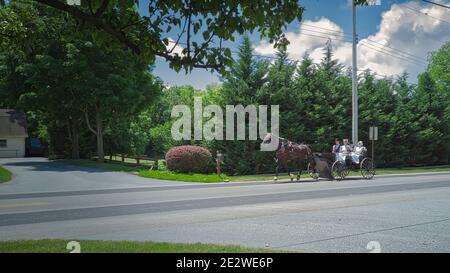 Gordonville, Pennsylvanie, le 2020 juin - un chariot ouvert Amish transportant deux couples Amish de l'église le jour de l'été Banque D'Images