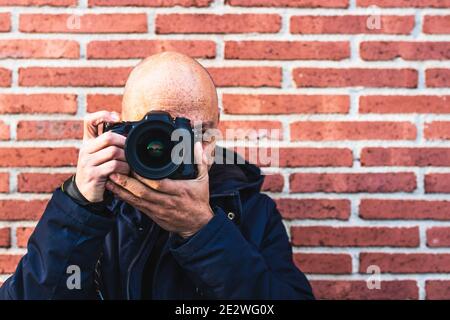 Homme photographiant en regardant son appareil photo en posant souriant Banque D'Images