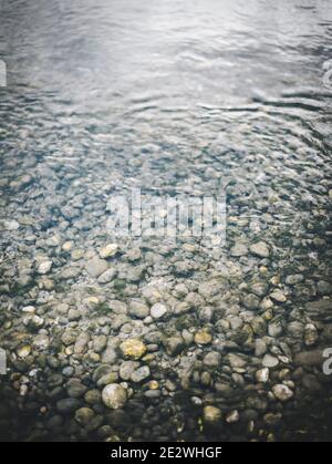 L'eau et les pierres ondulantes et les roches moussy sur le fond de la rive de la rivière Banque D'Images