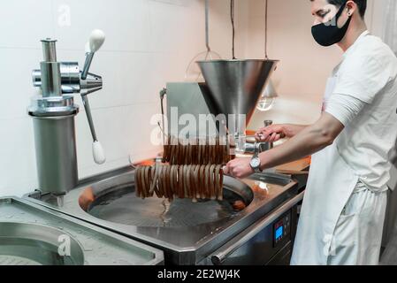 un serveur qui vous fait sortir les churros pour servir Banque D'Images