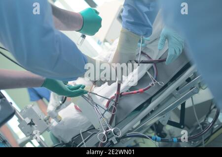 Mains du personnel médical travaillant à côté du lit du patient. Banque D'Images