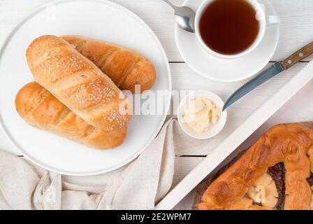 Le petit-déjeuner est composé de petits pains frais et de gâteaux faits maison sur un fond clair. Banque D'Images
