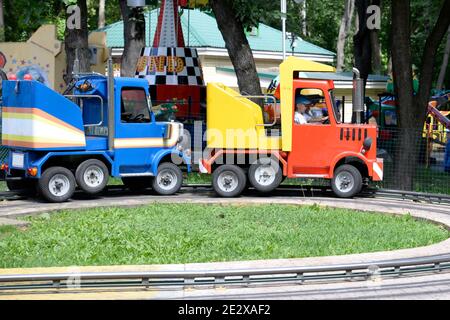 Enfants aux attractions du parc. Ils sont en train de taper. Banque D'Images