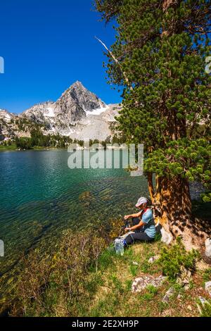 Eau de randonnée purifiante sur les rives du lac Treasure, John Muir Wilderness, Sierra Nevada Mountains, Californie États-Unis Banque D'Images