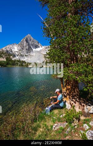 Eau de randonnée purifiante sur les rives du lac Treasure, John Muir Wilderness, Sierra Nevada Mountains, Californie États-Unis Banque D'Images