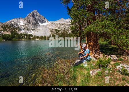 Eau de randonnée purifiante sur les rives du lac Treasure, John Muir Wilderness, Sierra Nevada Mountains, Californie États-Unis Banque D'Images