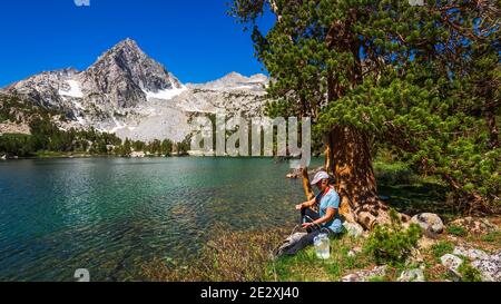 Eau de randonnée purifiante sur les rives du lac Treasure, John Muir Wilderness, Sierra Nevada Mountains, Californie États-Unis Banque D'Images