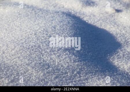 Neige blanche et fraîche étincelante au soleil avec des points forts et ombres pour l'arrière-plan Banque D'Images