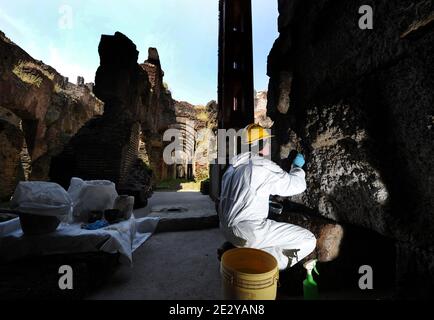 Exclusif. Un restaurateur travaille dans le sous-sol du Colisée à Rome, en Italie, le 2010 juin. Le Colisée de Rome, bientôt ouvert son arène, souterrain et niveau le plus élevé après une importante restauration. Pour la première fois, les touristes pourront visiter le sous-sol, où les gladiateurs se préparaient autrefois à des combats et où des lions et des tigres étaient mis en cage avant de recevoir un public assoiffé de sang. Les restaurateurs ont travaillé dur au nettoyage et à la restauration des colonnes de travertin et des briques anciennes. Le Colisée de Rome, le plus grand jamais construit dans l'Empire romain a été achevé en 80 après J.-C. avec une capacité de 75,000 spectateurs Banque D'Images