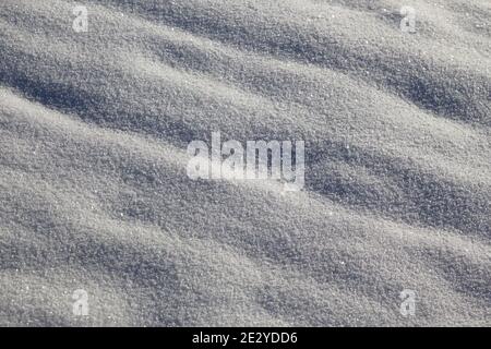 Neige blanche et fraîche étincelante au soleil avec des points forts et ombres pour l'arrière-plan Banque D'Images