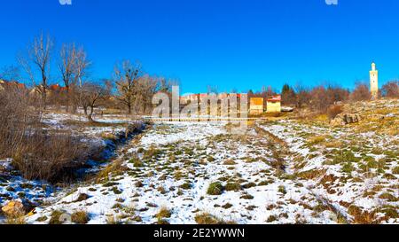 Des arbres bruns, de la neige blanche et un ciel bleu dans la ville d'Ifrane Banque D'Images